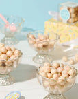 white chocolate balls with colorful sprinkles in them inside clear glass dishes