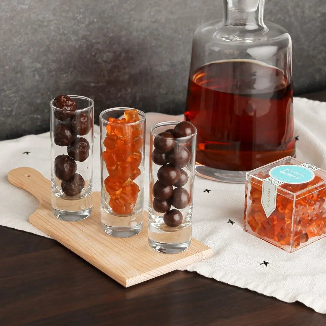 Bourbon Bears in candy cube next to shot glasses full of candy and whiskey decanter in the background