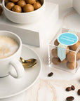 Cappuccino Cordials in dish and in candy cube, next to coffee on saucer