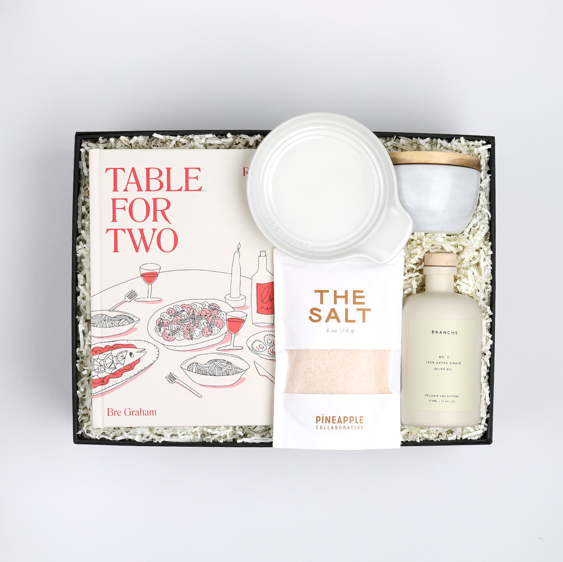 Table for Two ready to ship in black featuring &quot;Table for Two&quot; cookbook, Le Creuset spoon rest, Branche olive oil, The Salt, and marble salt cellar