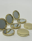 gold compact mirrors lined up next to each other, some opened, some closed