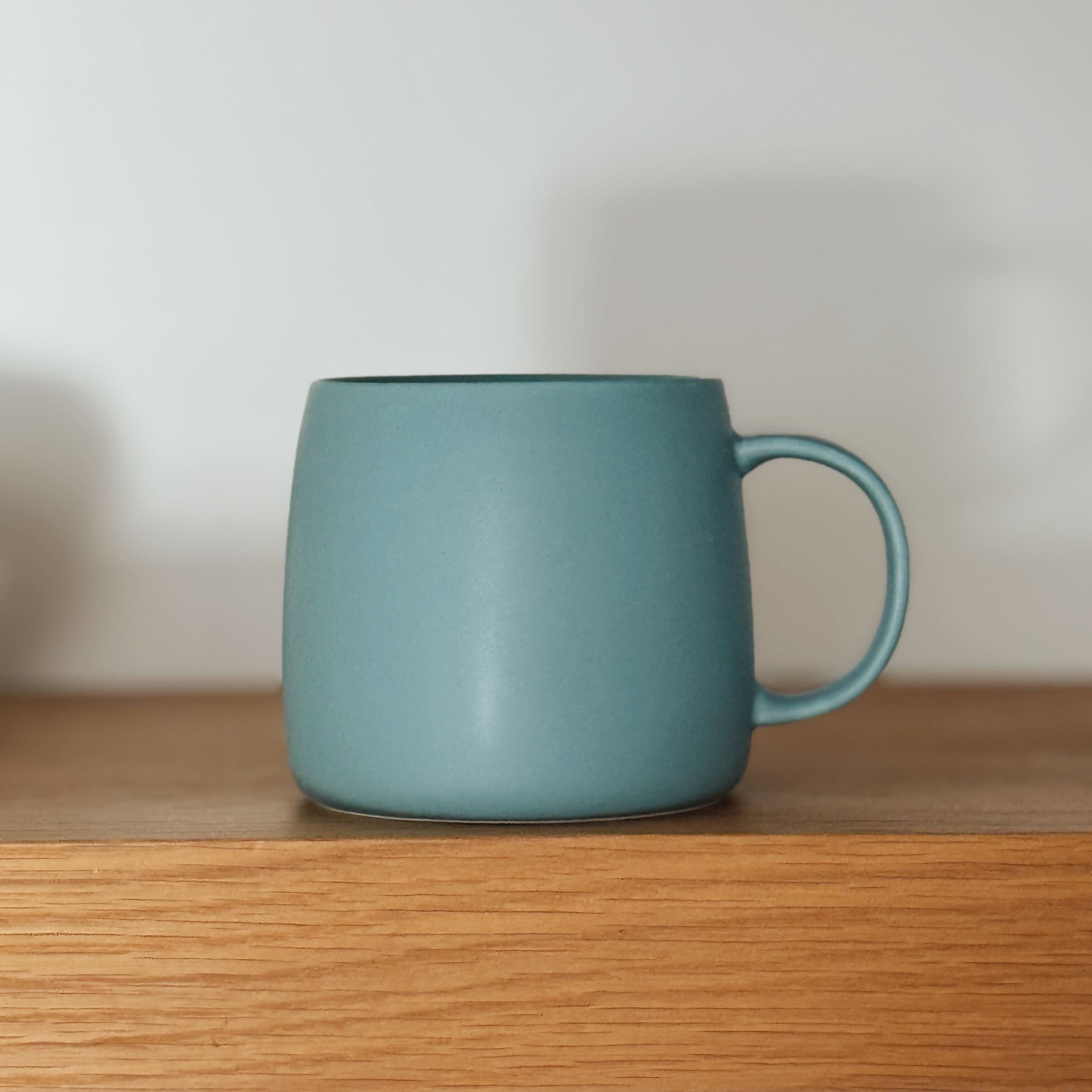 Blue mug on a wooden surface with a neutral background