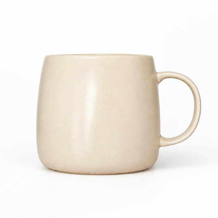White ceramic mug on a wooden surface with a plain background