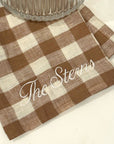 Checkered placemat with 'The Steins' text on a white surface