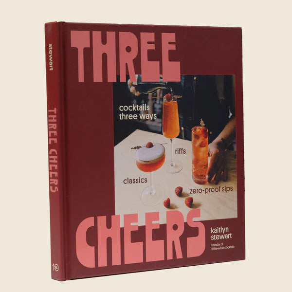 Book titled 'Three Cheers' with cocktail-themed cover on a beige background