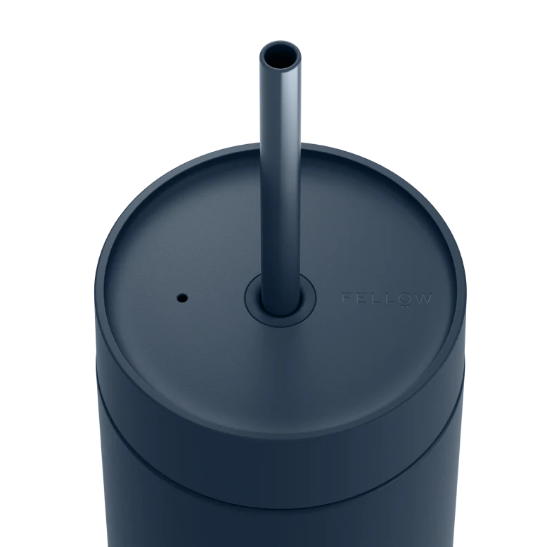 Dark blue tumbler with a straw on a white background