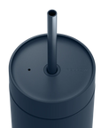 Dark blue tumbler with a straw on a white background