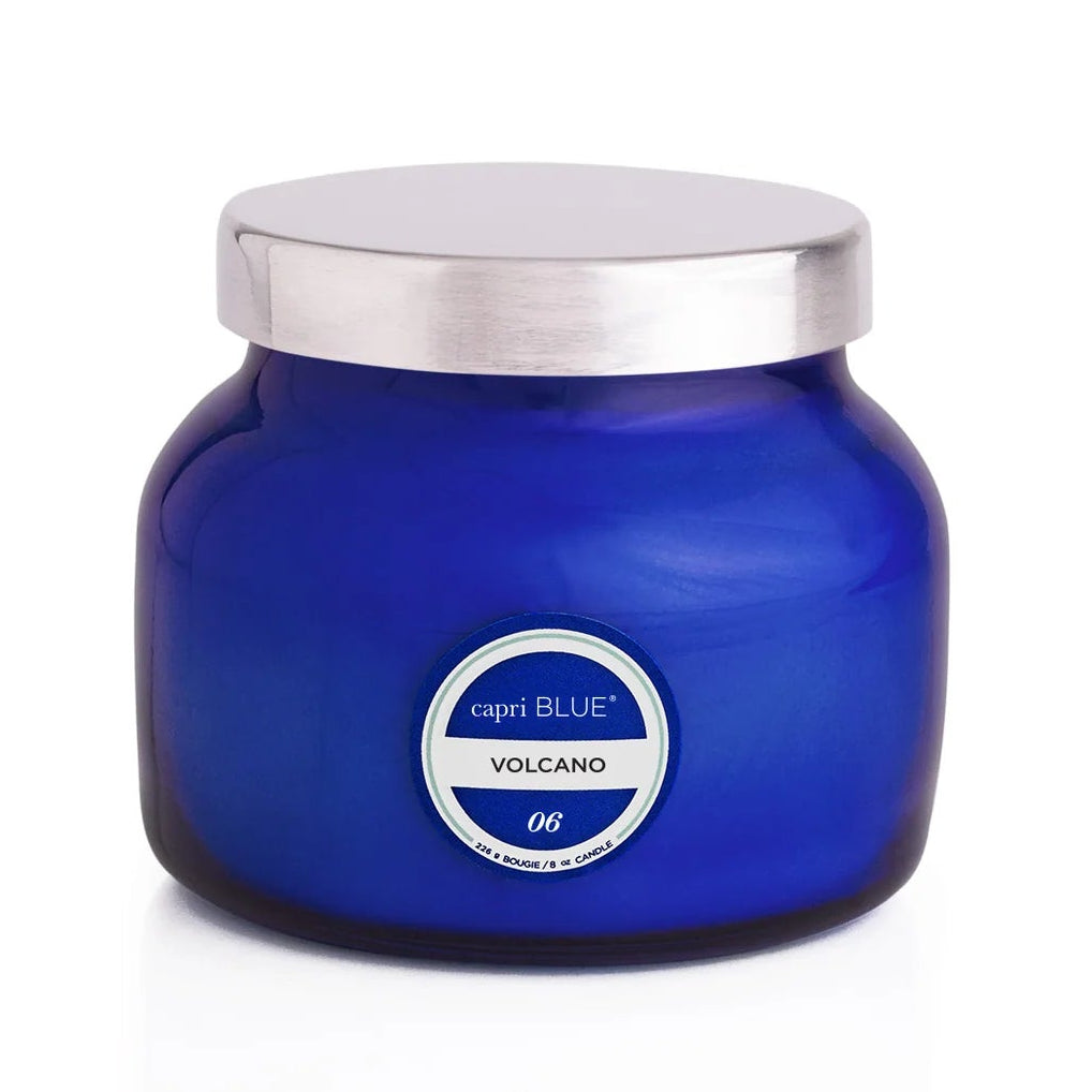 Blue candle jar with silver lid on a white background