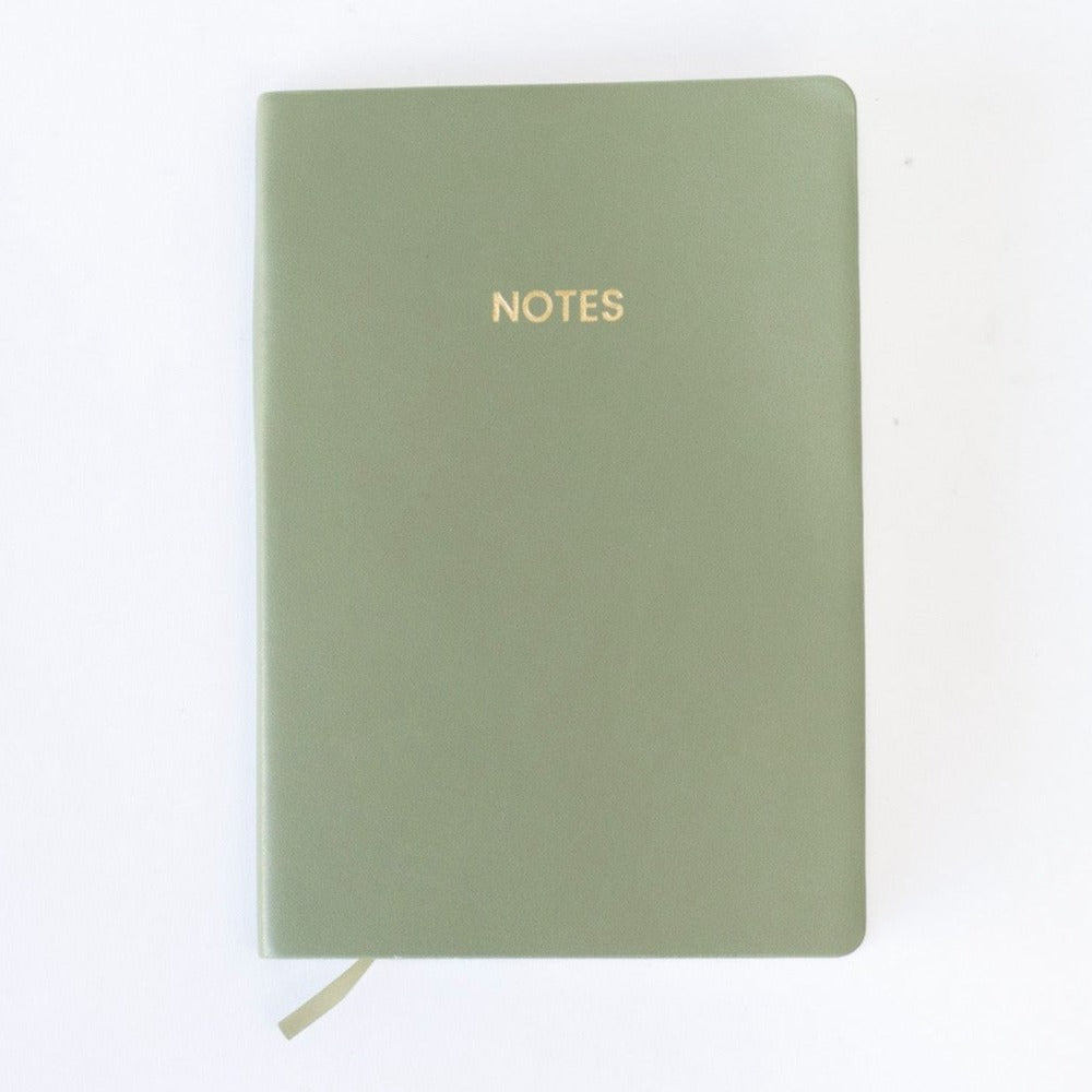 An olive green colored vegan leather notebook with gold foil text reading "NOTES" across the front photographed against a white background.