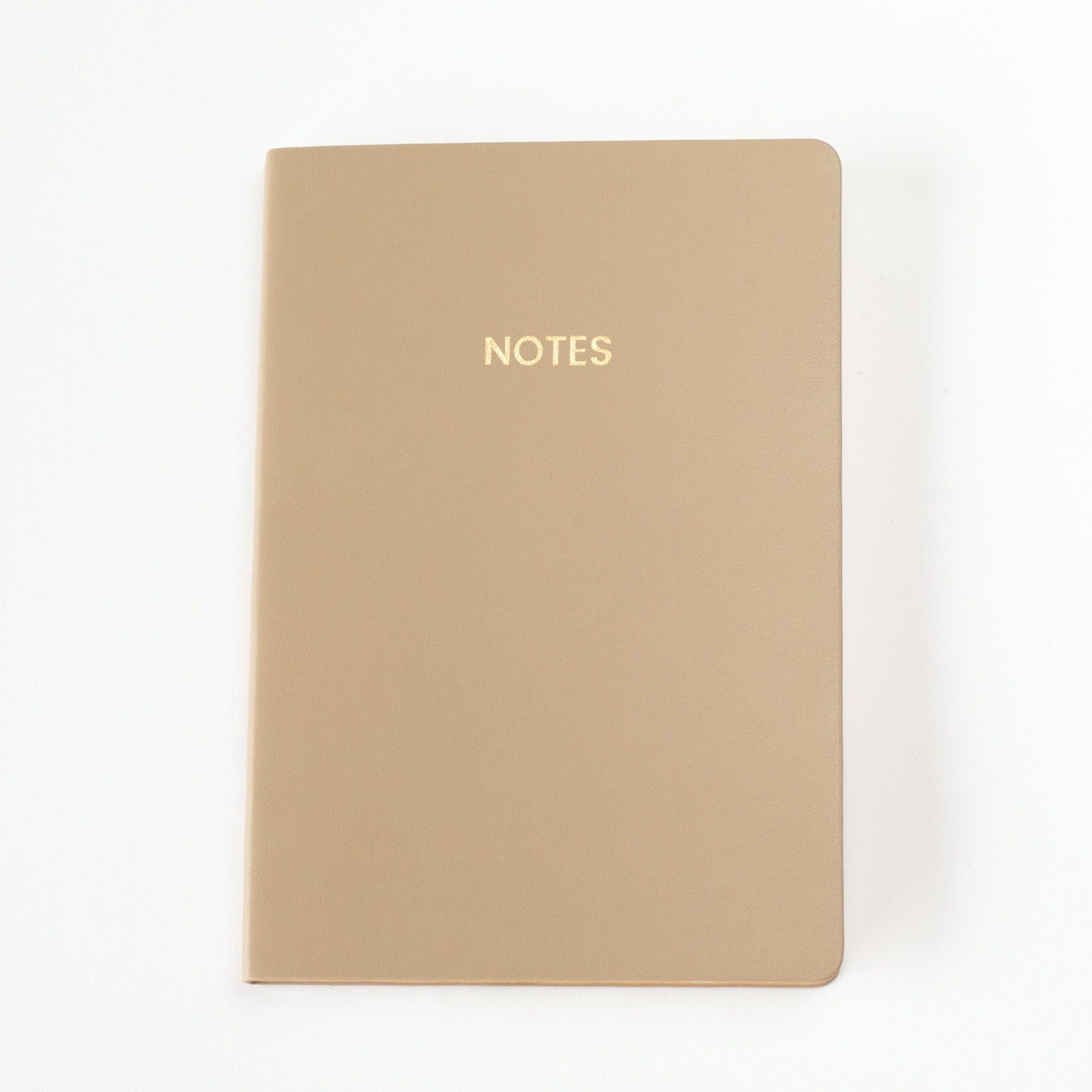 A light brown colored vegan leather notebook with gold foil text reading &quot;NOTES&quot; across the front photographed against a white background.