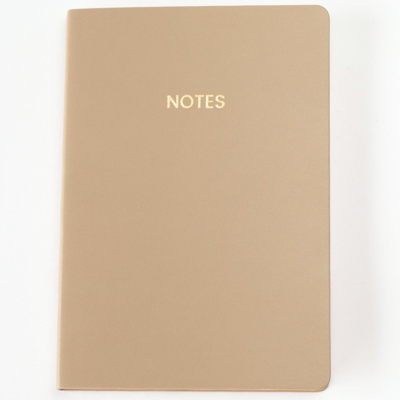 A light brown colored vegan leather notebook with gold foil text reading &quot;NOTES&quot; across the front photographed against a white background.