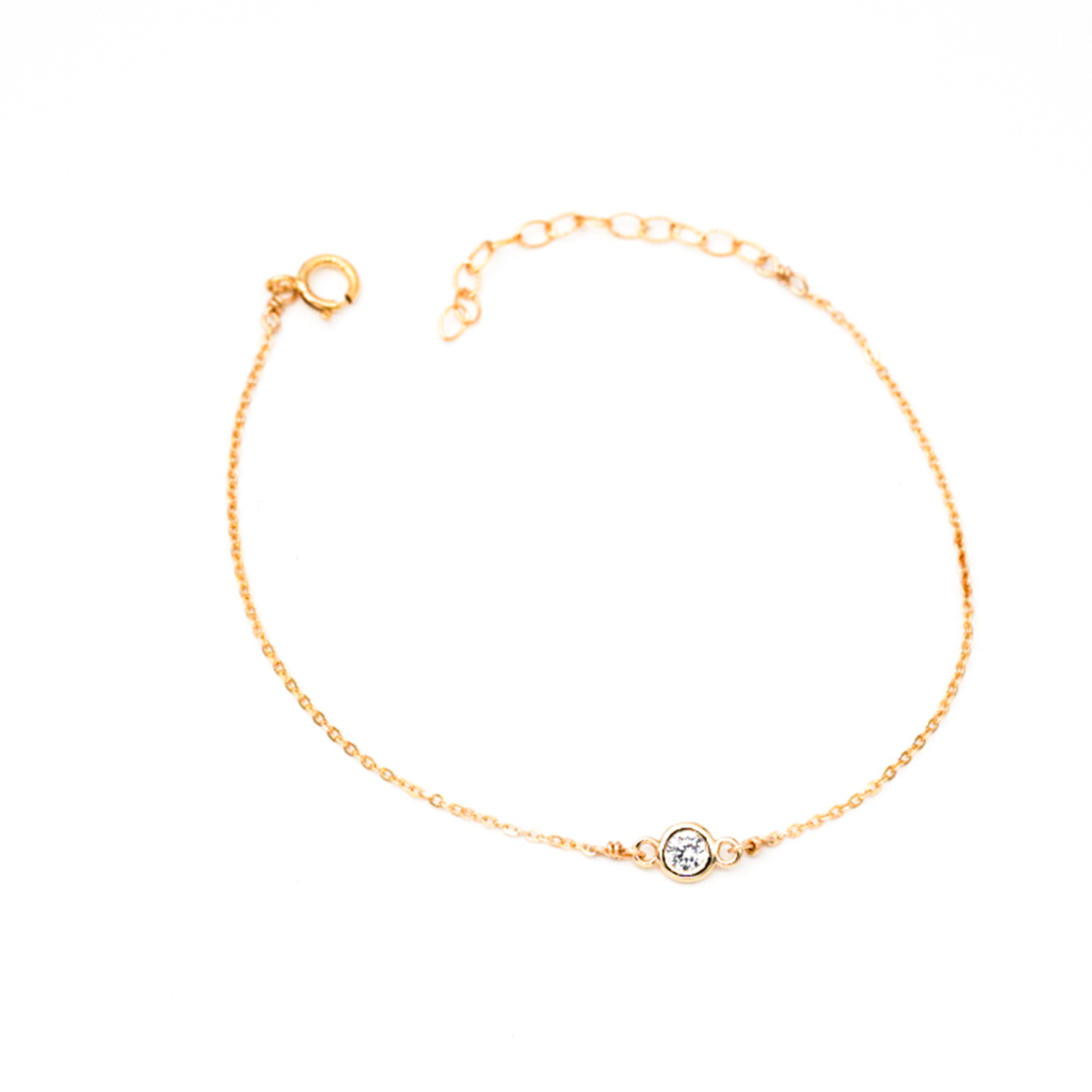 Dainty gold chain with small circular diamond in center.