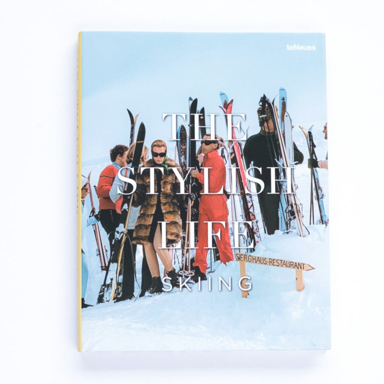 A hardcover book with photograph of posh, fur coat wearing skiiers as cover with large large white text reading, "The Stylish Life Skiing".