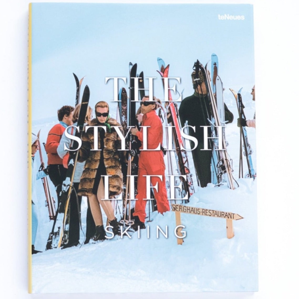 A hardcover book with photograph of posh, fur coat wearing skiiers as cover with large large white text reading, "The Stylish Life Skiing".