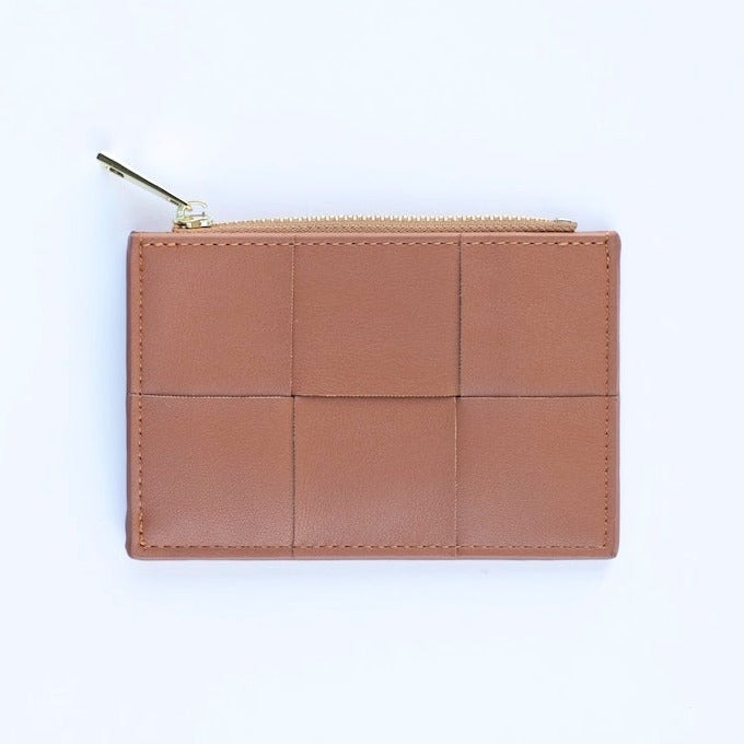 A caramel brown colored woven vegan leather card case wallet with a gold zipper. photographed against a white background.