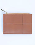A caramel brown colored woven vegan leather card case wallet with a gold zipper. photographed against a white background.