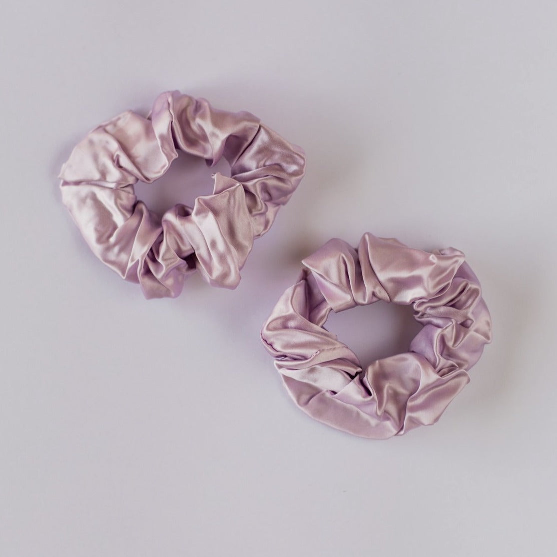 Two lilac thick silk scrunchies on white background.