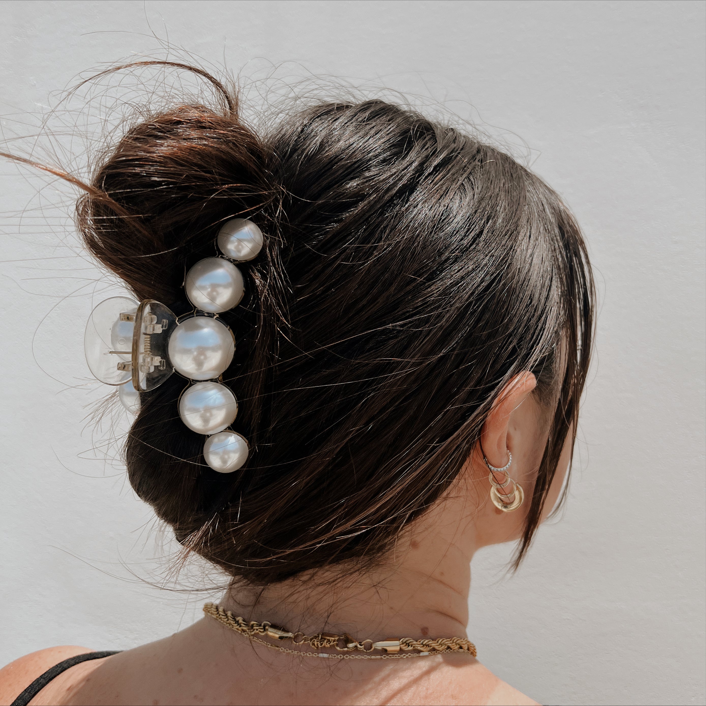 Brunette with Pearl claw clip pulling back hair