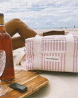 pink striped premium cooler bag on the sand at the beach