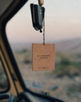 golden coast car fragrance hanging on the rear view mirror of a car