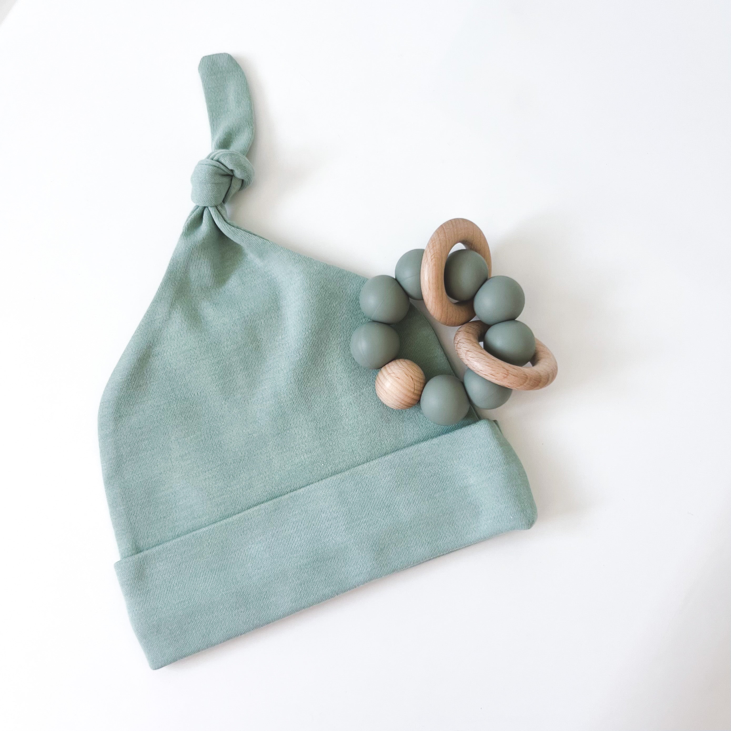 Green alva baby beanie with sage green silicone and wood teether