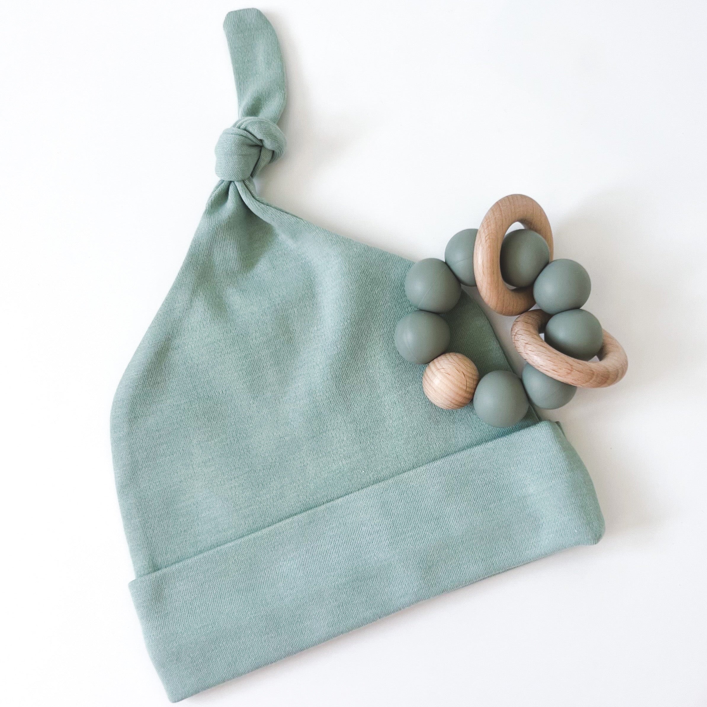 Green alva baby beanie with sage green silicone and wood teether