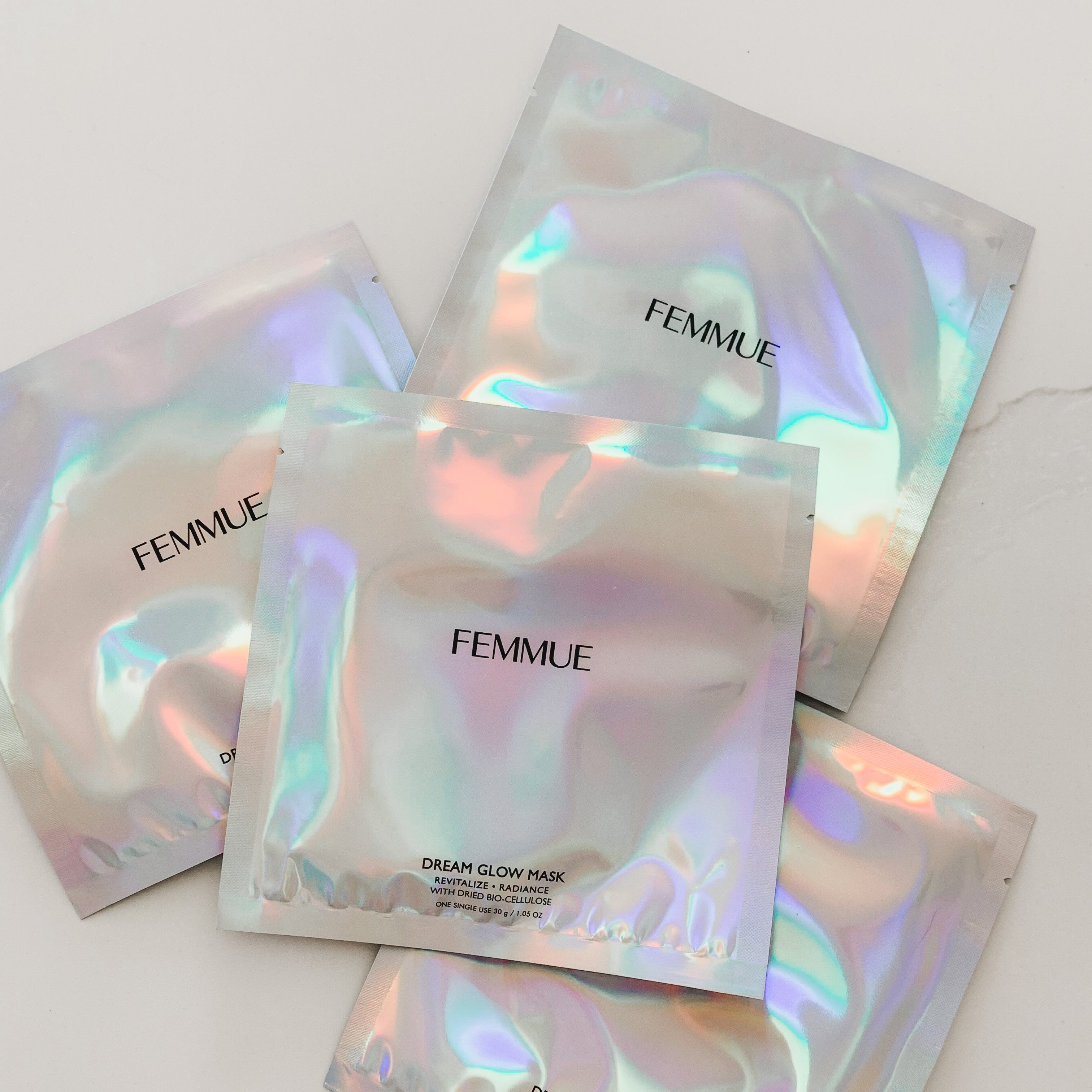 Iridescent square package of four face masks.