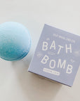 Blue bath bomb next to blue box with white text.