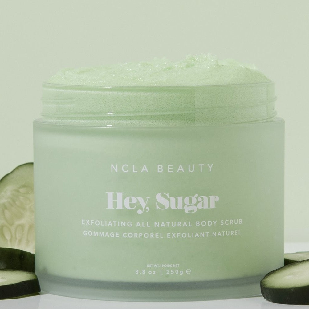 Cucumber sugar scrub in clear packaging, surrounded by cucumber slices.