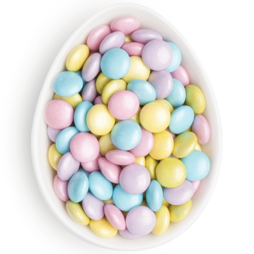 pink, purple, blue, and yellow coated chocolate pieces in white oval dish