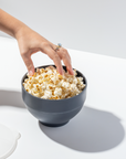 Hand reaching into black W&P popcorn bowl