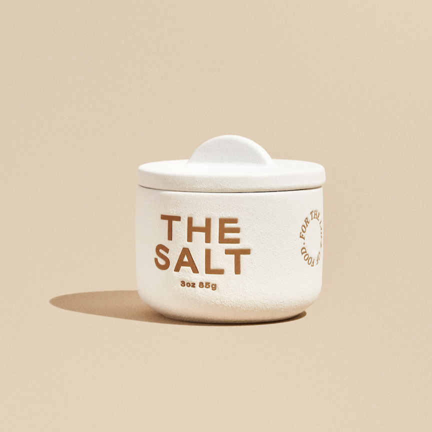 White ceramic salt cellar that has "THE SALT" in brown font across the front.