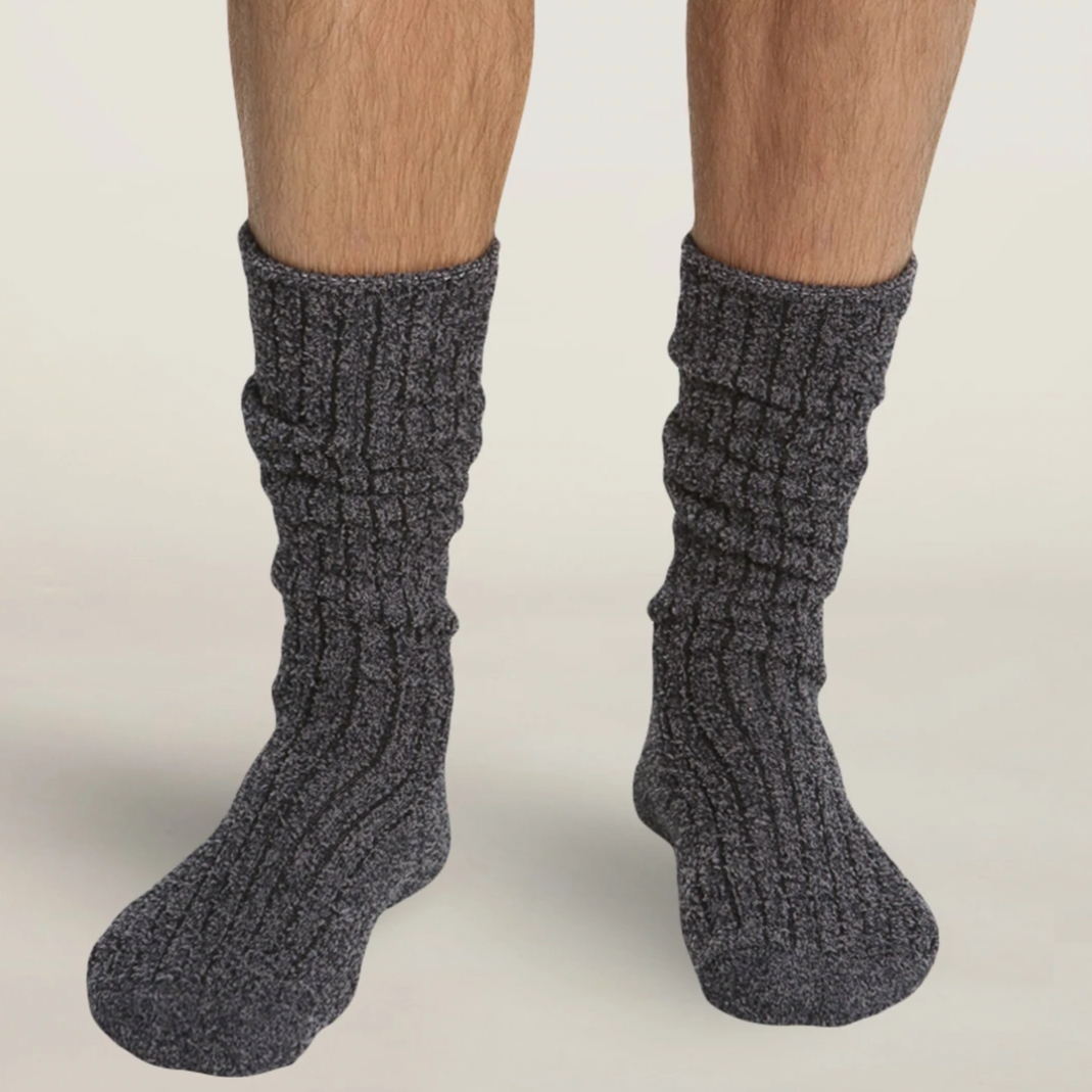 Man&#39;s legs from knees down wearing dark grey fuzzy socks.