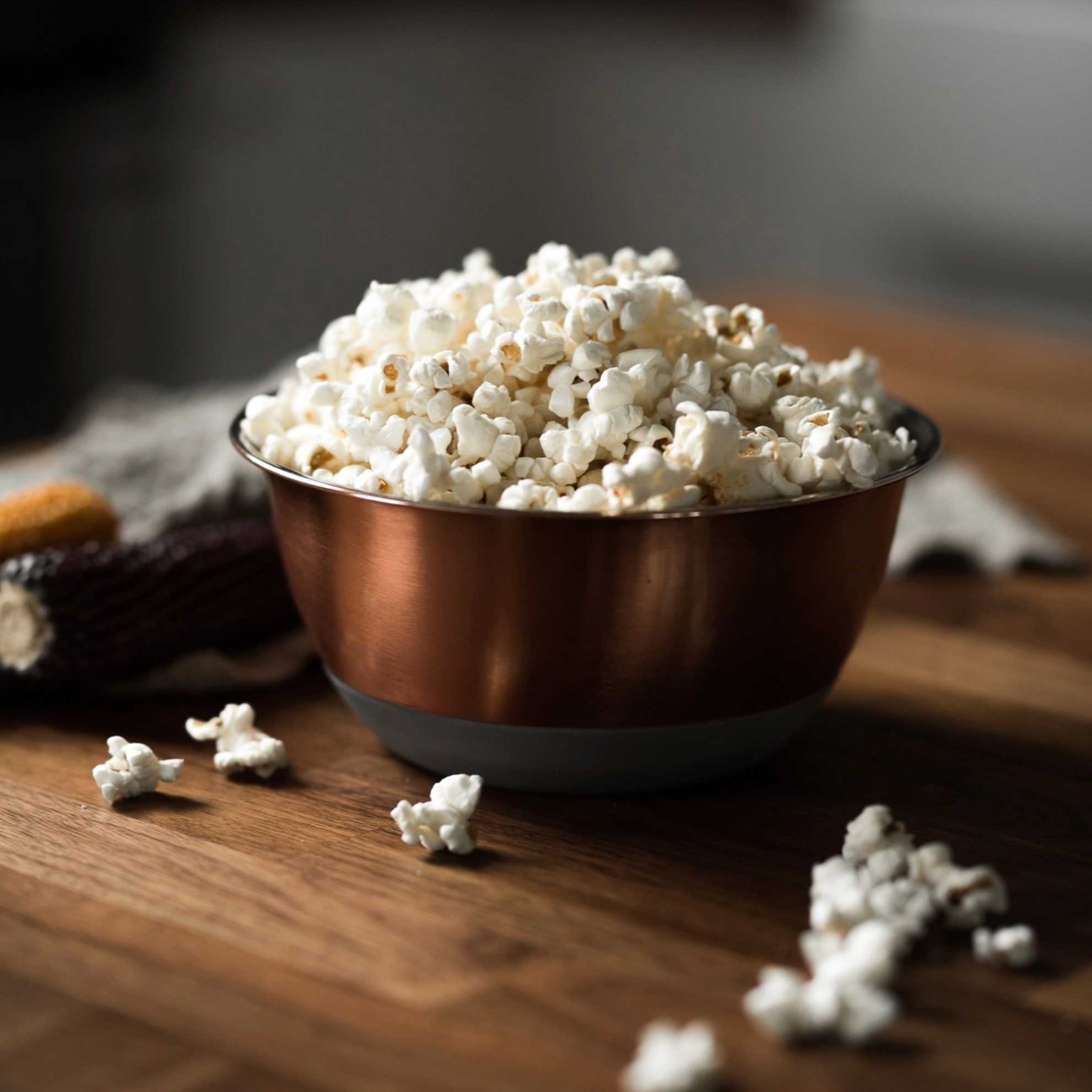 bowl of popped popcorn sitting on a wooden table