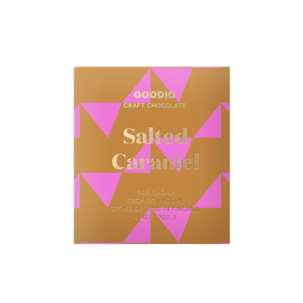 A square chocolate bar packaged in beige and pink geometric design paper. Gold leaf writing on package reads, "GOODIO Craft Chocolate Salted Caramel 49% Cacao Organic + Vegan Stone Ground in Finland 48G (1.7 OZ)". Photographed on white background.  