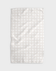 A white tea towel with beige grid design folded into a rectangle and photographed on white background.