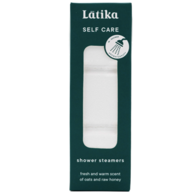 A tall rectangular dark teal box with clear window in middle showing stack of white shower steamers. White text on packaging reads, "Latika Self Care Shower Steamers fresh and warm scent of oats and raw honey"