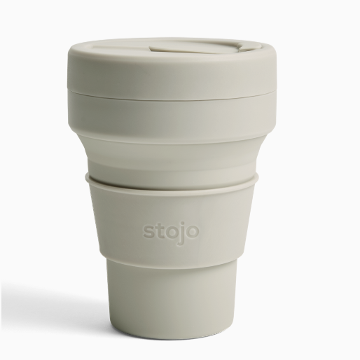 Plastic beige mug with silicone sleeve that reads, &quot;stojo&quot; photographed on white background. 