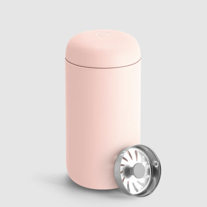 A matte blush pink insulated mug with silver drip guard insert leaning on right side.