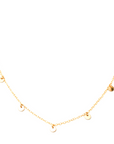 Image is of the Five Coin necklace on a white background, which consists of a thin gold chain with small gold disks hanging about 1 inch apart from each other.