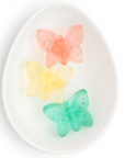 White ceramic dish with a pink, a yellow and a green baby butterfly each.