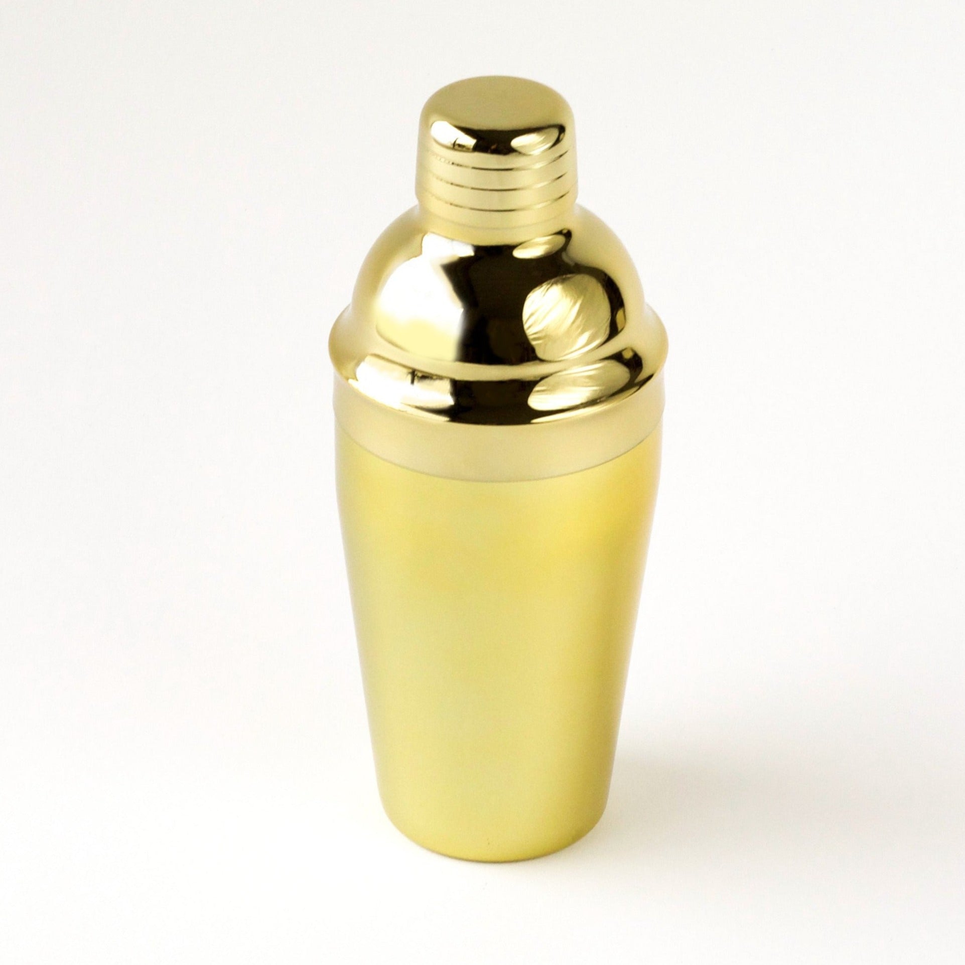 A gold cocktail shaker sitting on a white background.