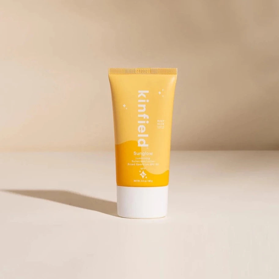 yellow and orange sunscreen bottle with white lid. has white text reading &quot;Kinfield Sunglow Laminating Sunscreen&quot; 