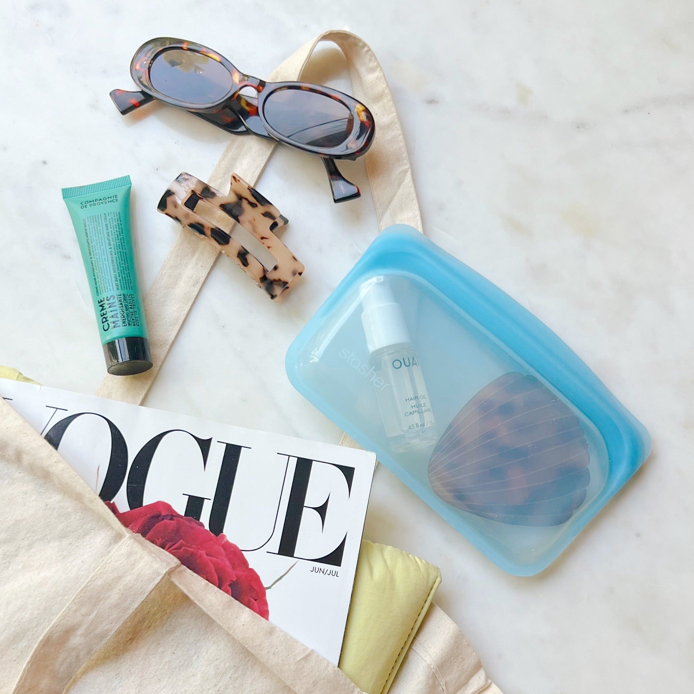 Small blue bag filled with hair essentials spilling out from tote bag.