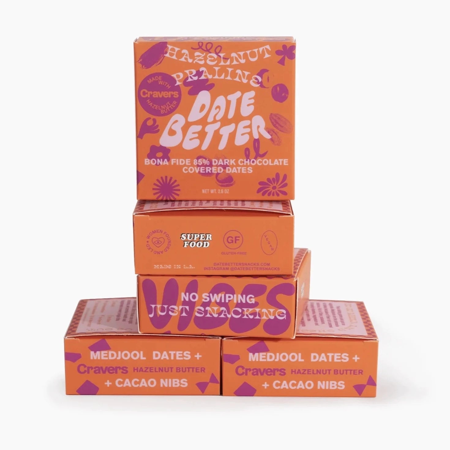 Orange square box with purple illustrations all over it. Text is on the front and in white. Text Reads &quot;hazelnut praline date better bonafide 85% dark chocolate covered dates&quot;
