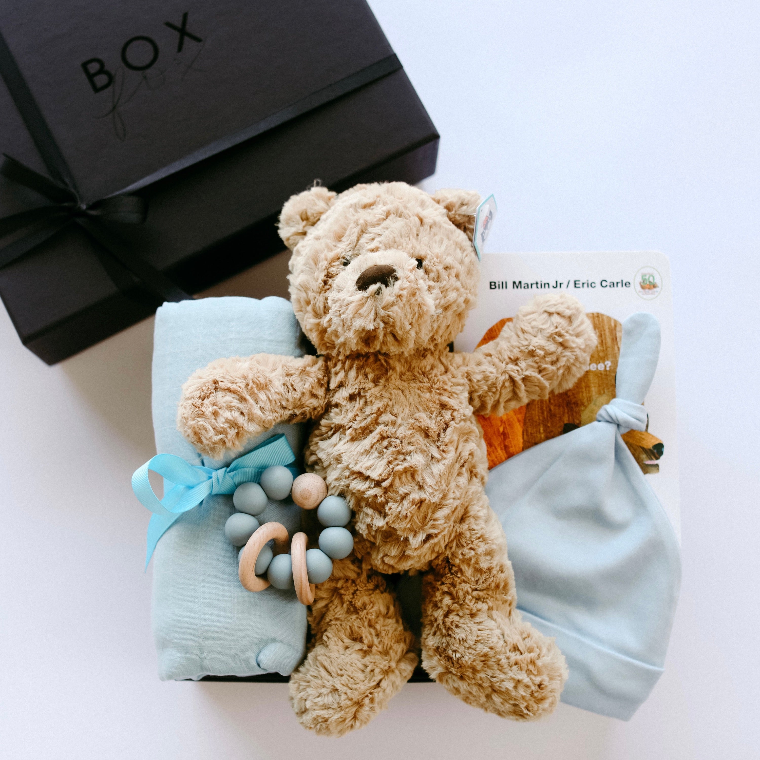 BOXFOX Matte Black Gift Box with &quot;Brown Bear, Brown Bear&quot; Board Book, Alva Blue Knotted Baby Beanie, Alva Blue Wood Teething Ring, Alva Blue Swaddle and Jelly Cat Bumble Bear.