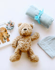 "Brown Bear, Brown Bear" Board Book, Alva Blue Knotted Baby Beanie, Alva Blue Wood Teething Ring, Alva Blue Swaddle and Jelly Cat Bumble Bear on white background.