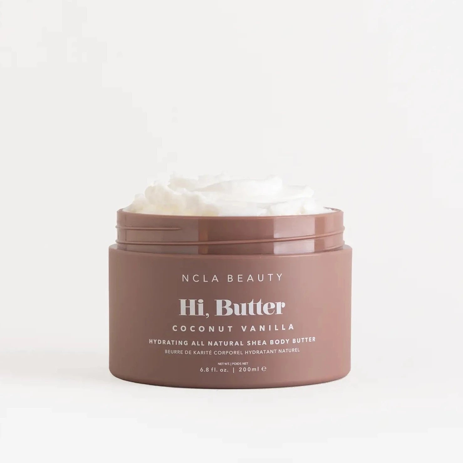 coconut vanilla body butter in brown container. the lid is off showing the whipped texture of the body butter