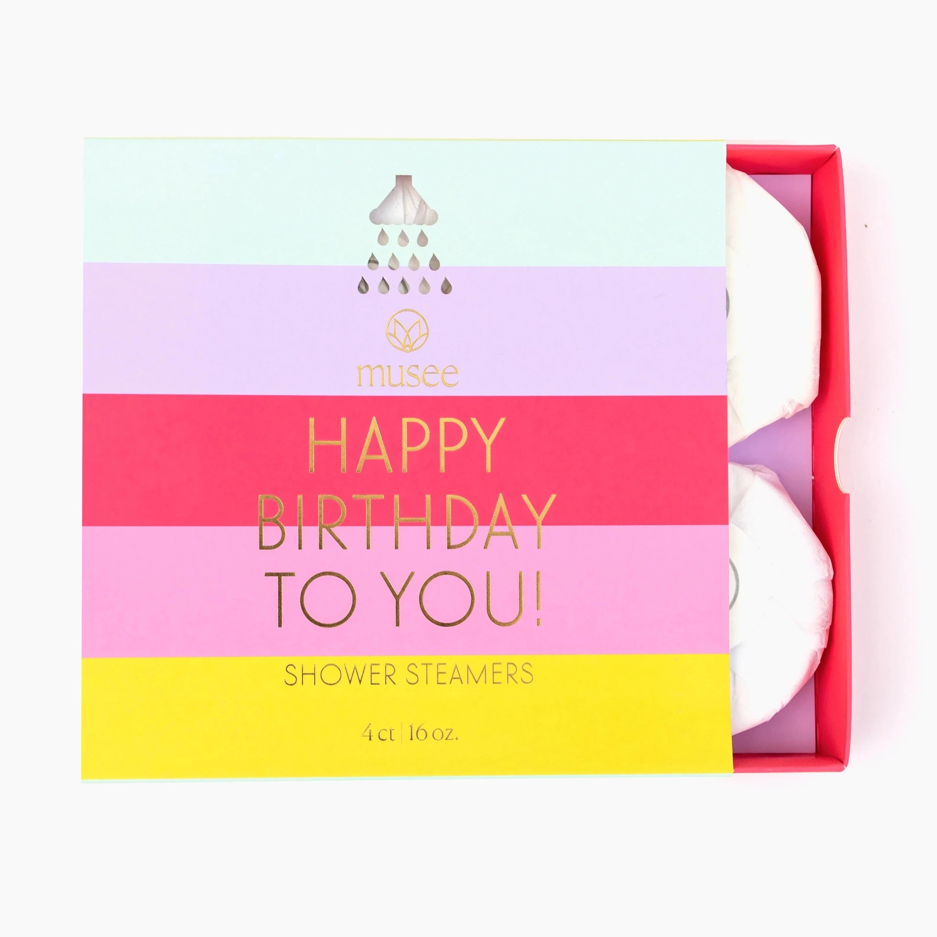 Shower steamer packaging with stripes across the from in Blue, purple, red, pink, and yellow. Gold text that reads "Happy Birthday to You Shower Steamers- 4ct" Box is slightly opened to show shower steamers inside that are wrapped in white paper